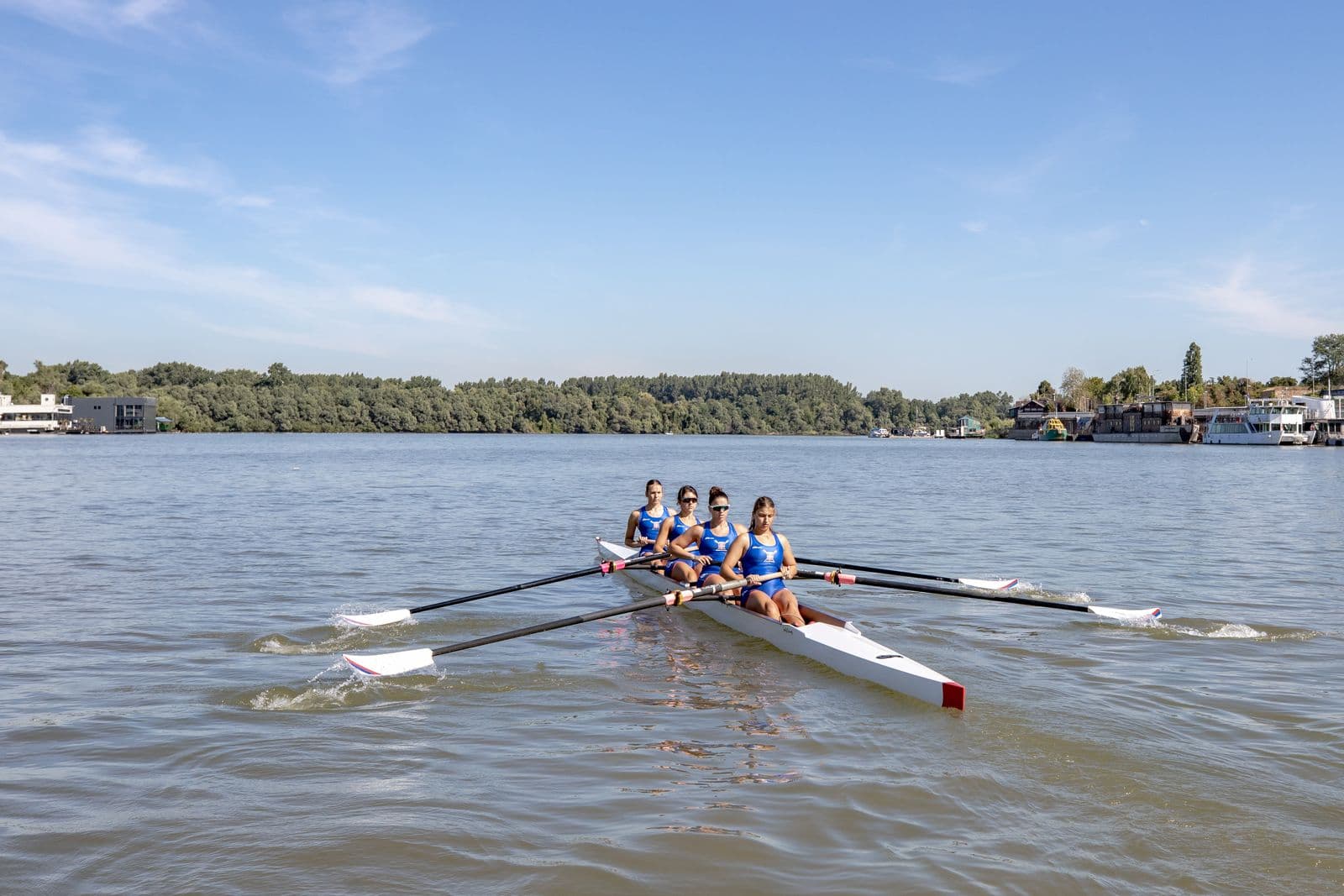 Rowers' hands on oar handles mid-stroke