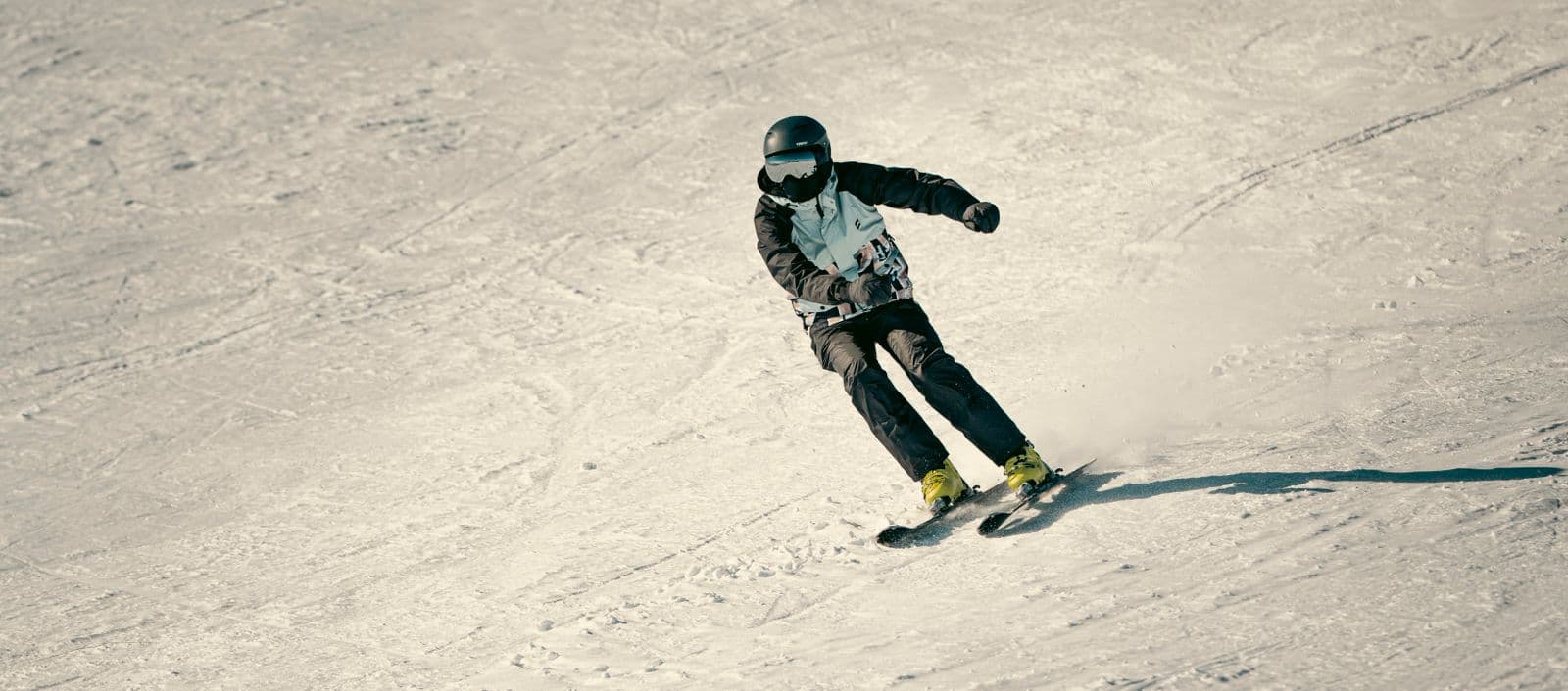 Skier carving a controlled turn on a groomed run