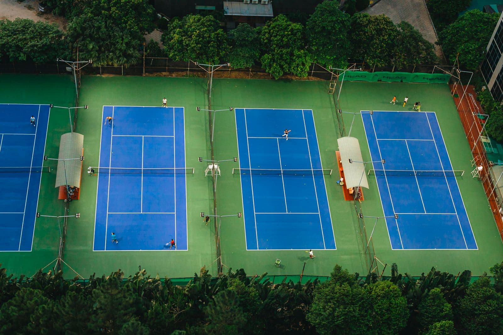 Busy outdoor tennis courts seen from above