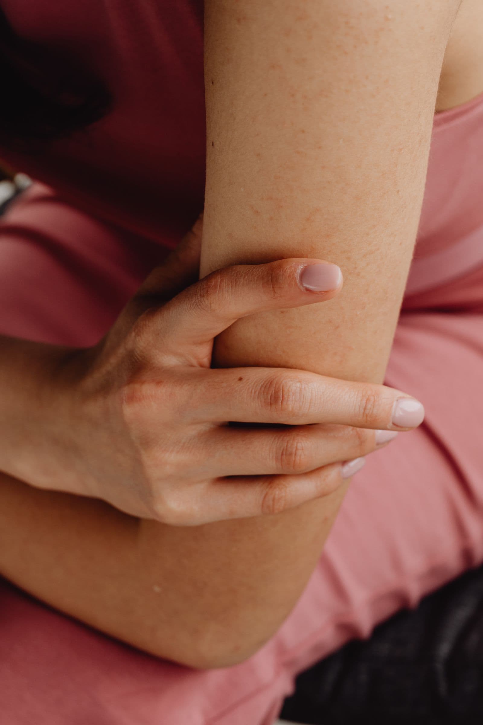 Close-up of a hand holding a sore elbow