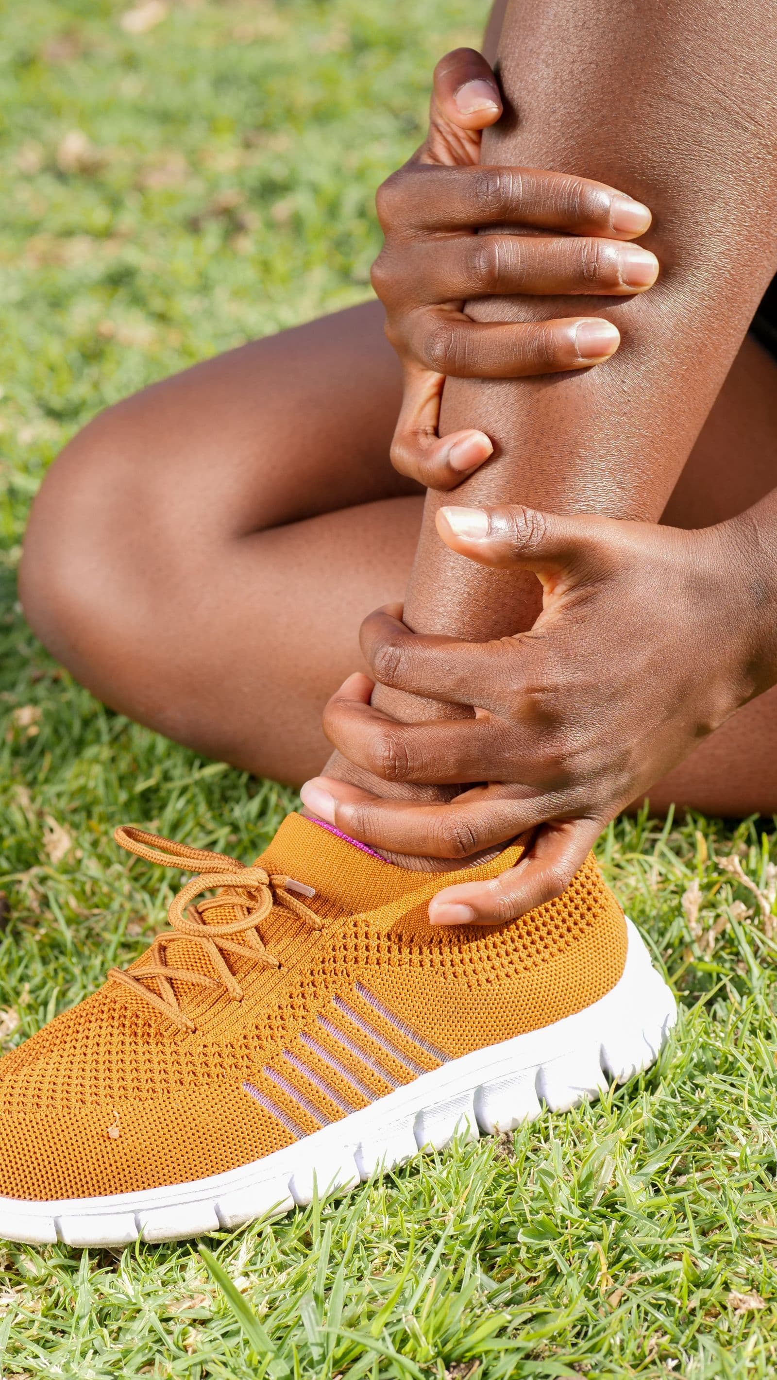 Player sitting and holding their ankle in discomfort