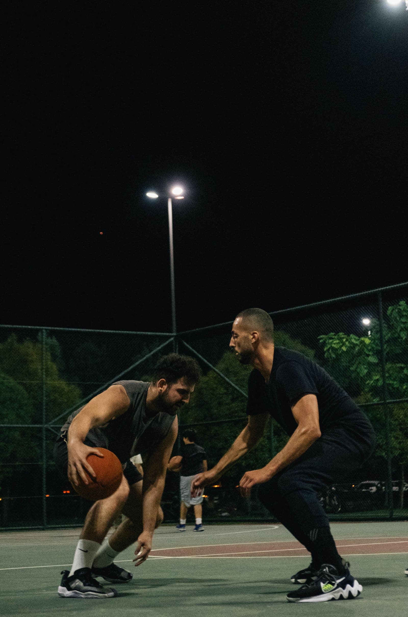 Two players in a night game on an outdoor court