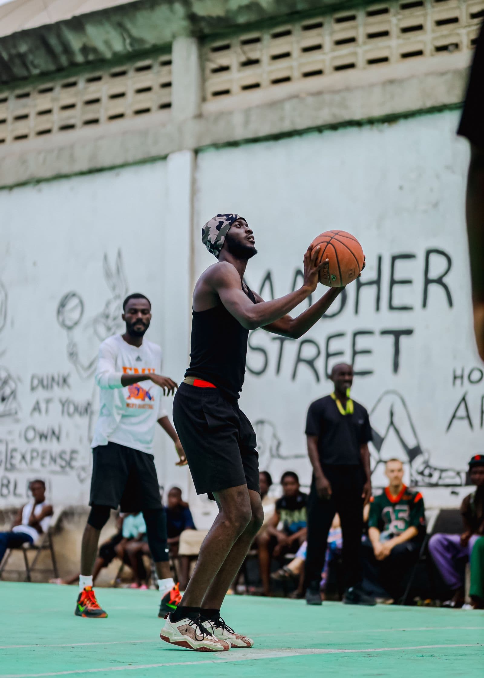 Players in a street basketball game on an outdoor court