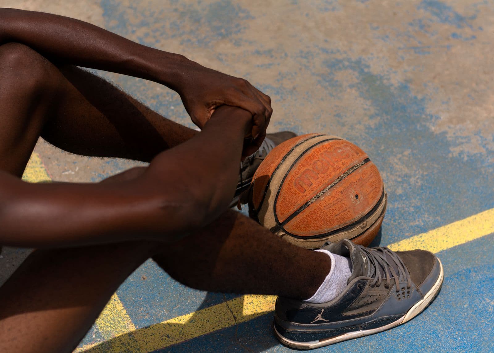 Basketball player resting on an outdoor court