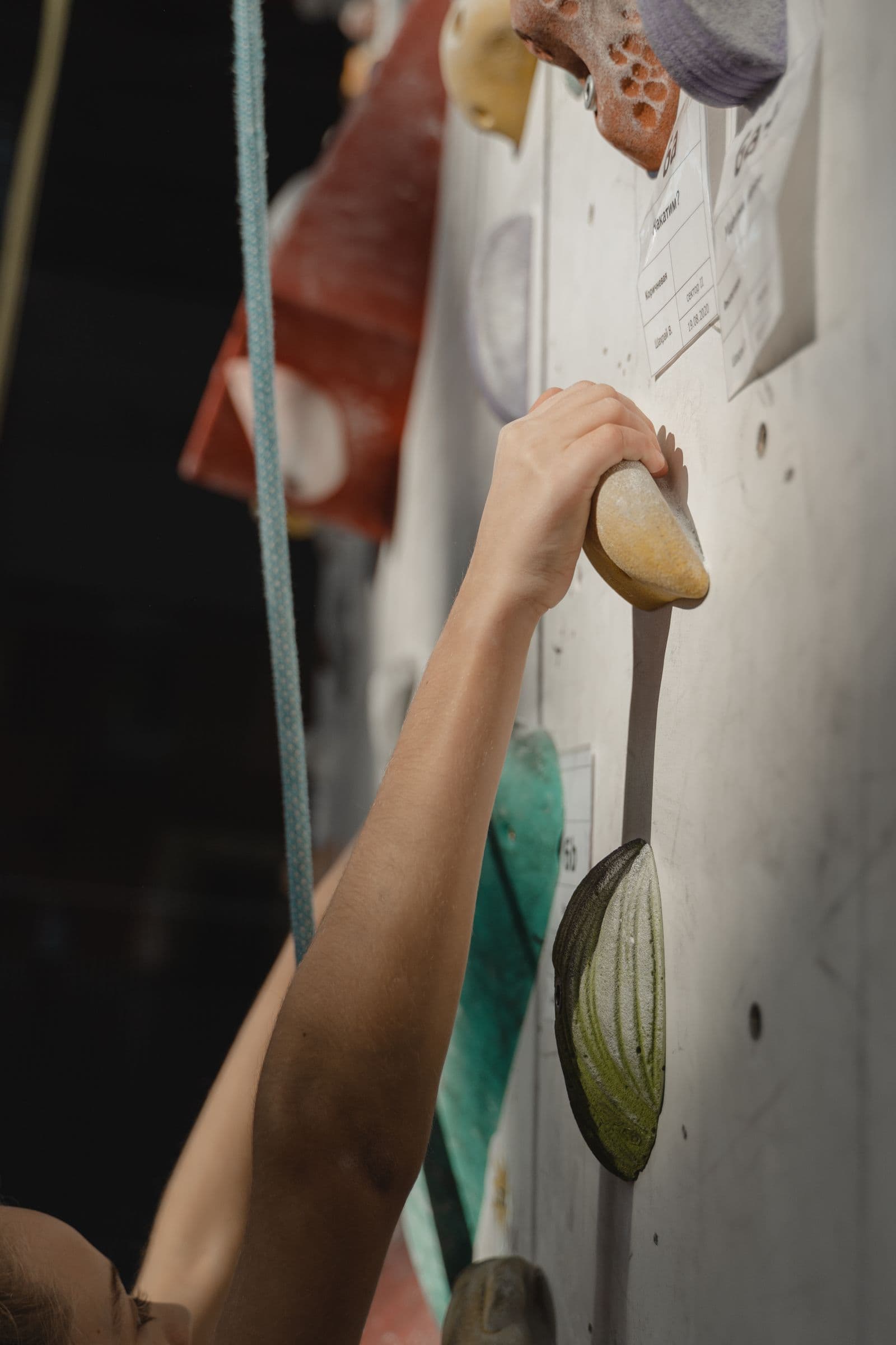 Close-up of a climber's hand gripping an indoor wall hold