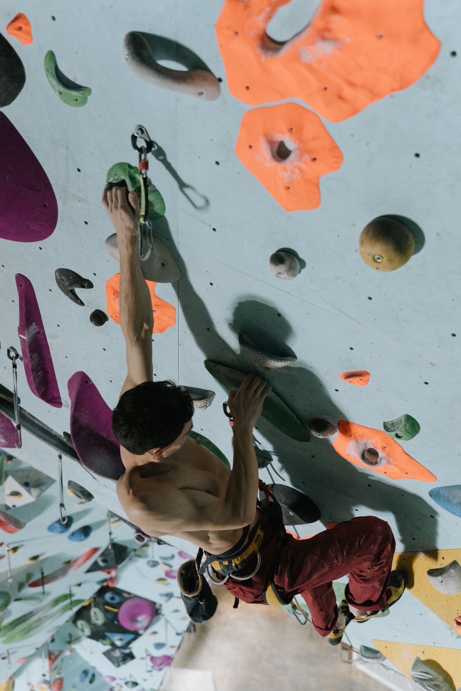 Climber reaching overhead on a vibrant indoor rock wall