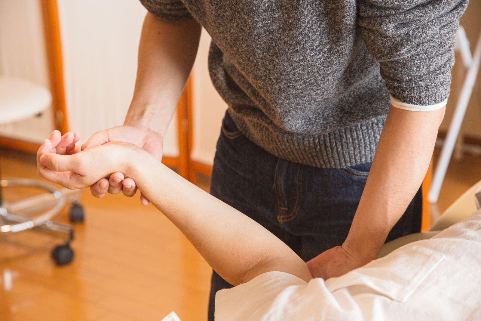 Clinician examining a patient's hand and wrist