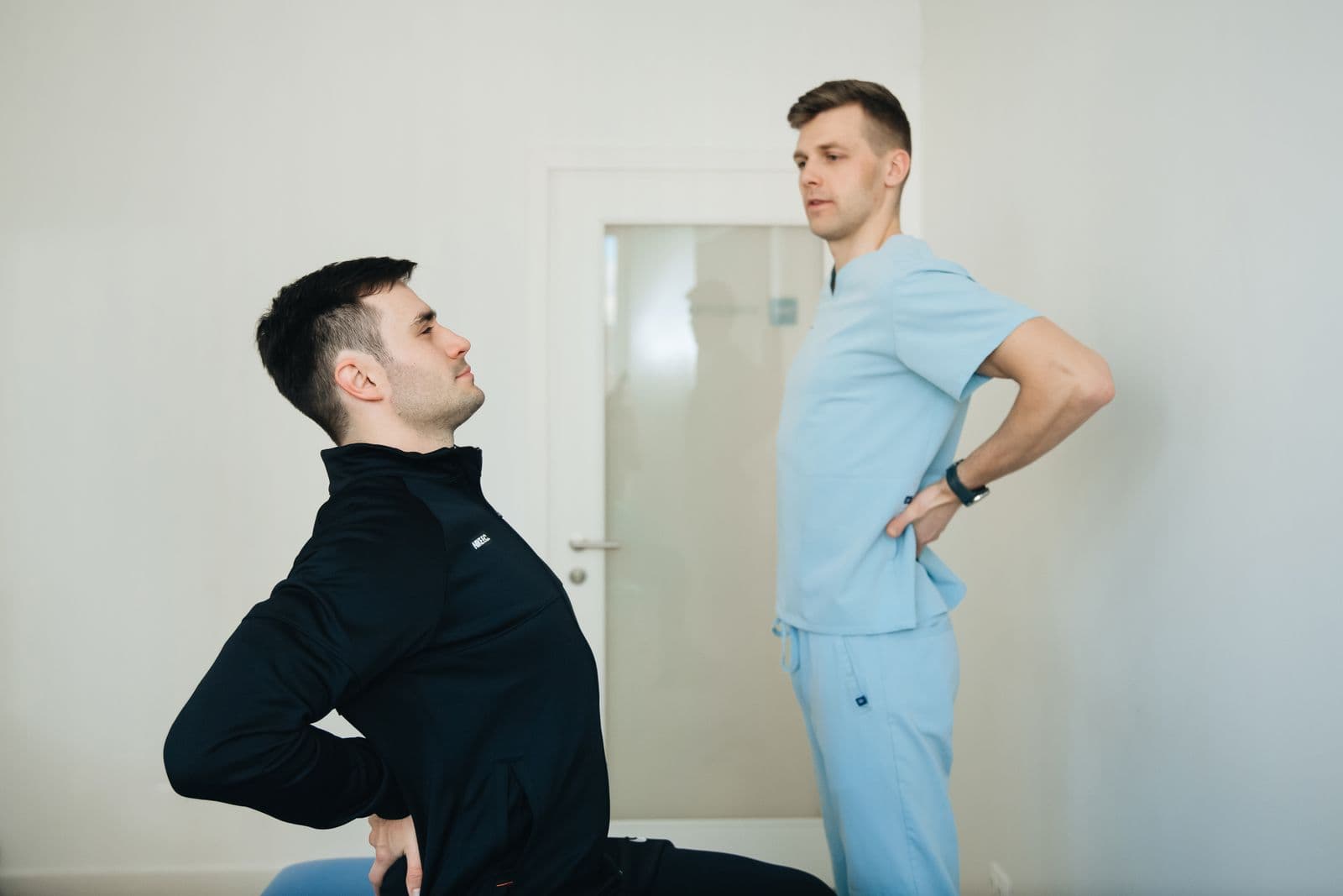 Physical therapist guiding a patient through a back exercise