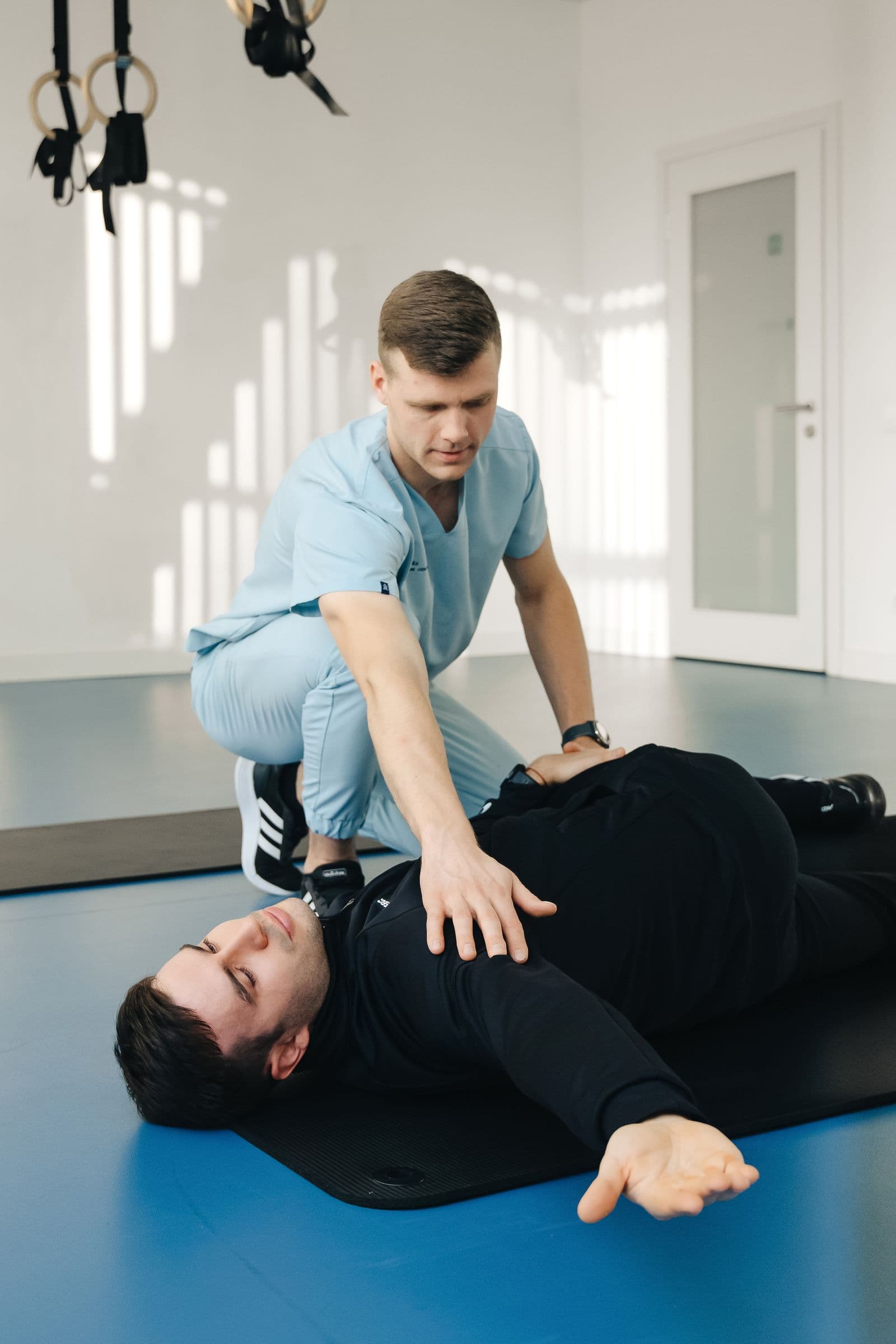 Physical therapist assisting a patient with a floor exercise