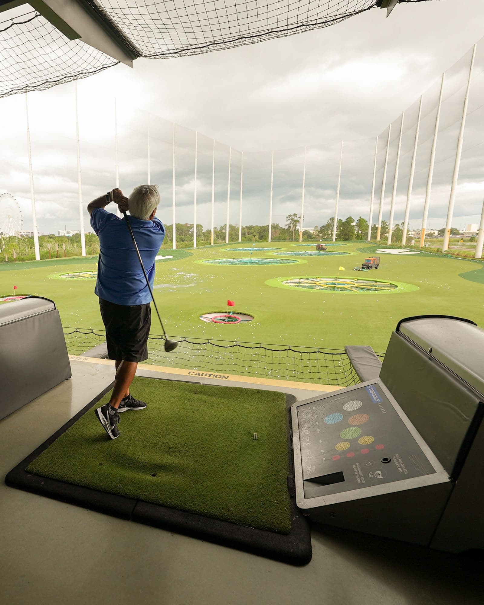 Golfer practicing his swing at a driving range