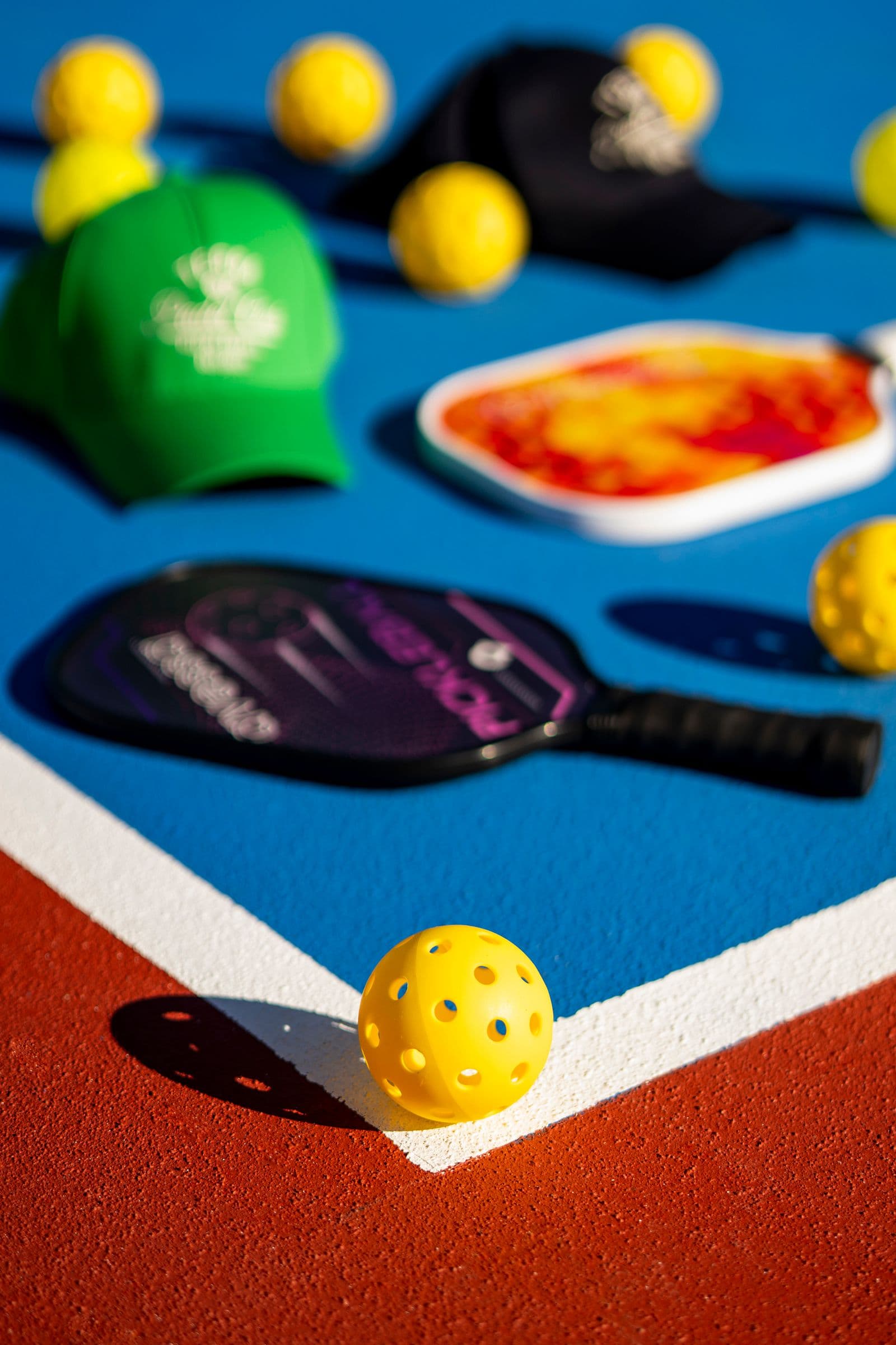 Pickleball paddles, balls, and gear laid out on a court