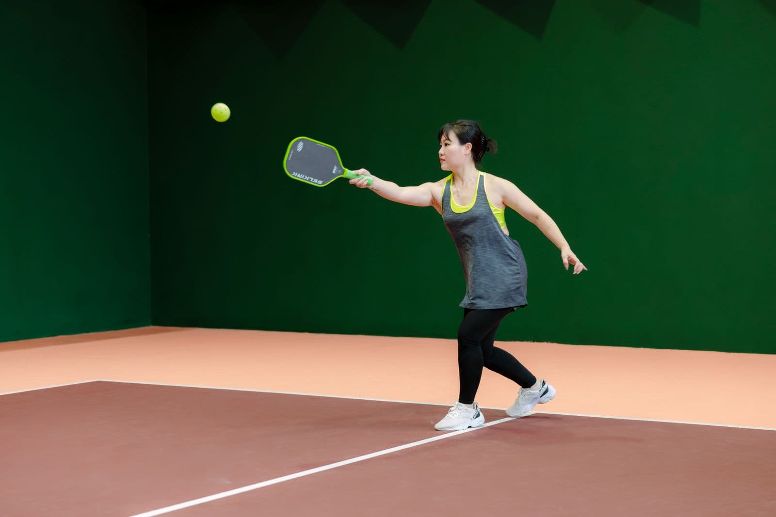 Pickleball player moving for a shot on an indoor court