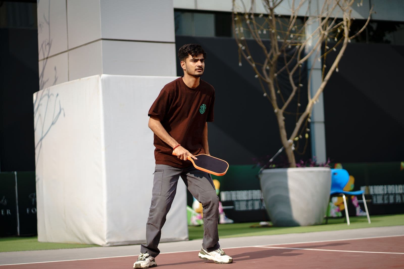 Pickleball player lunging for a shot on an outdoor court