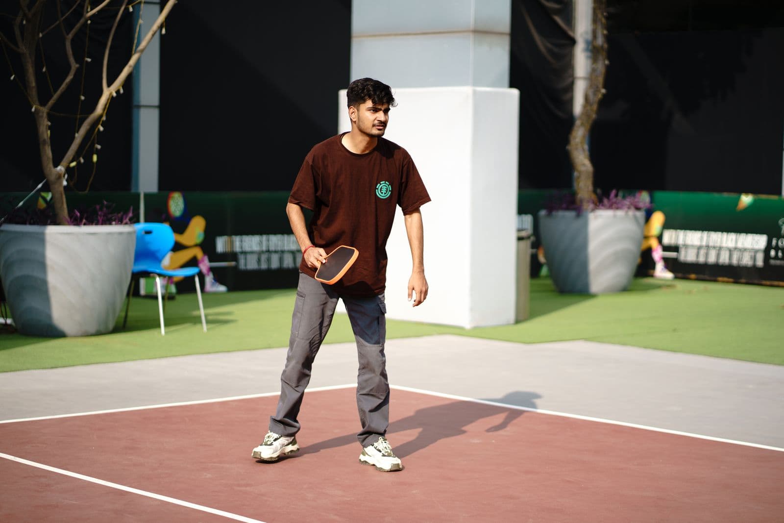 Pickleball player reaching for a shot on an outdoor court