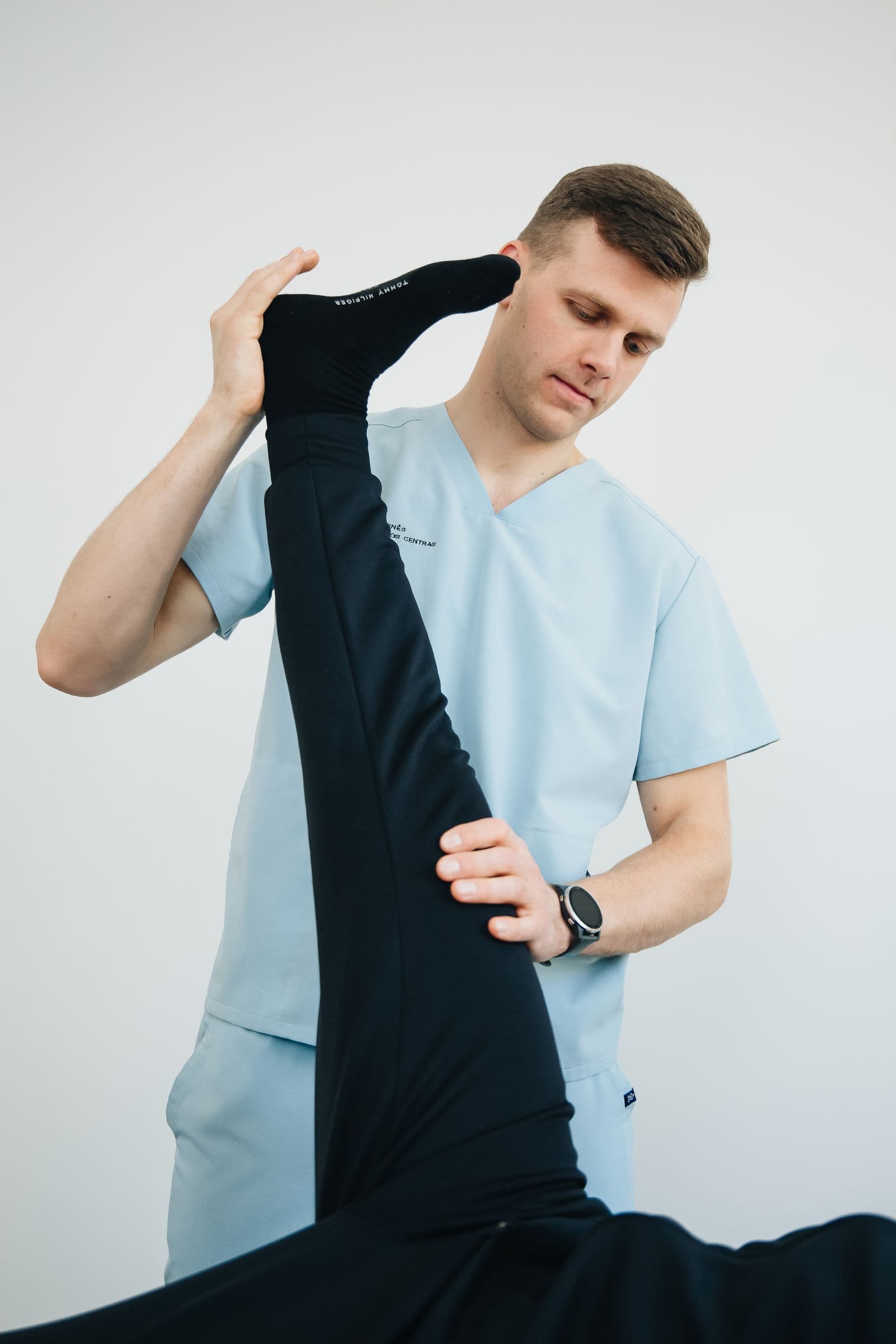 Physical therapist assessing a patient's knee and leg in a clinic