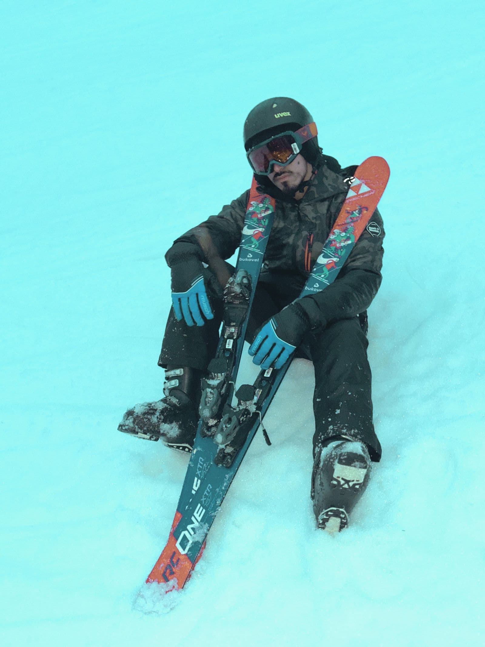 Skier sitting on the snow after a fall, skis off