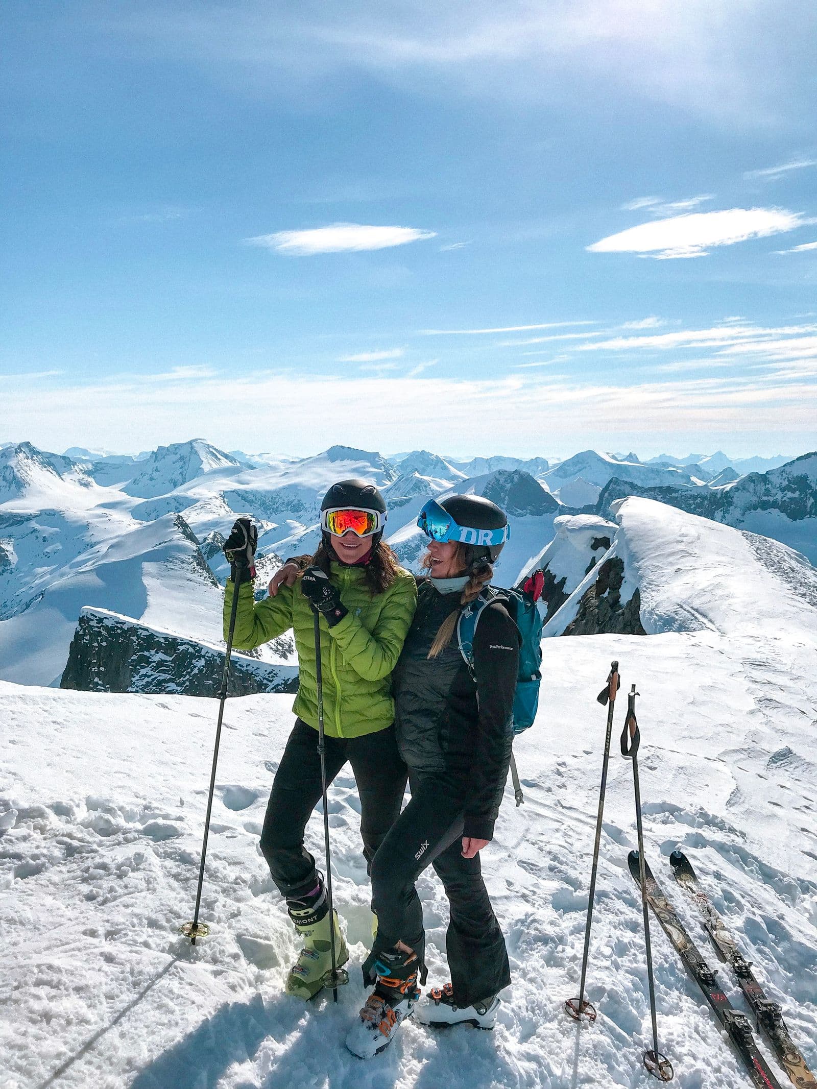 Two skiers on a sunny mountain with panoramic views