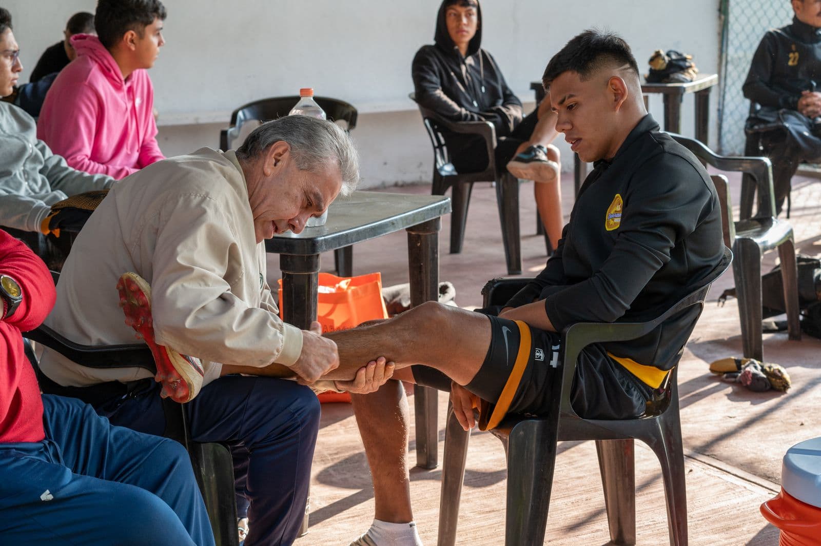 Coach checking a young soccer player's leg on the field