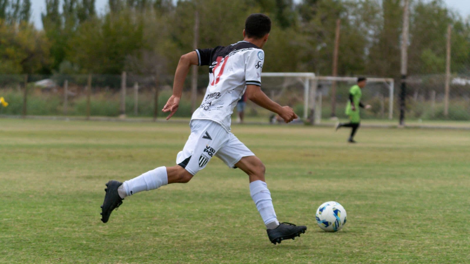 Soccer player sprinting toward goal with the ball