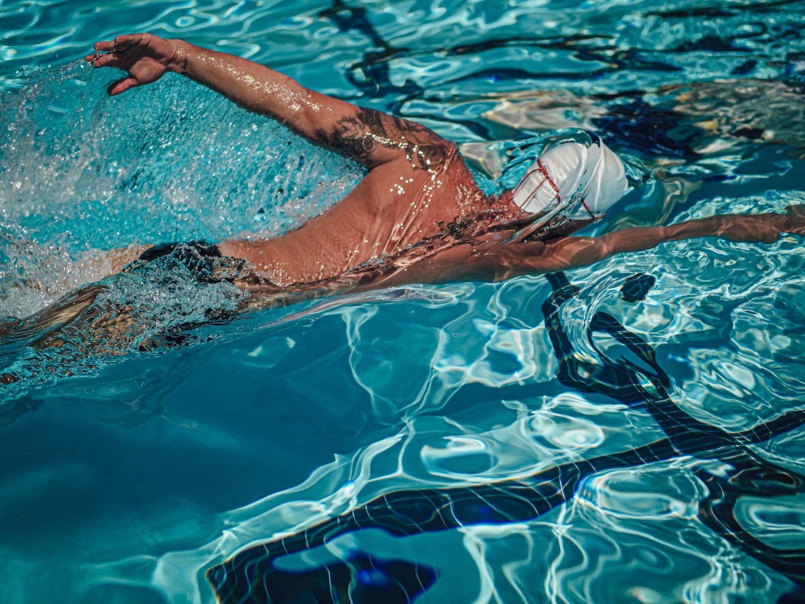 Swimmer mid-freestyle stroke in an outdoor pool