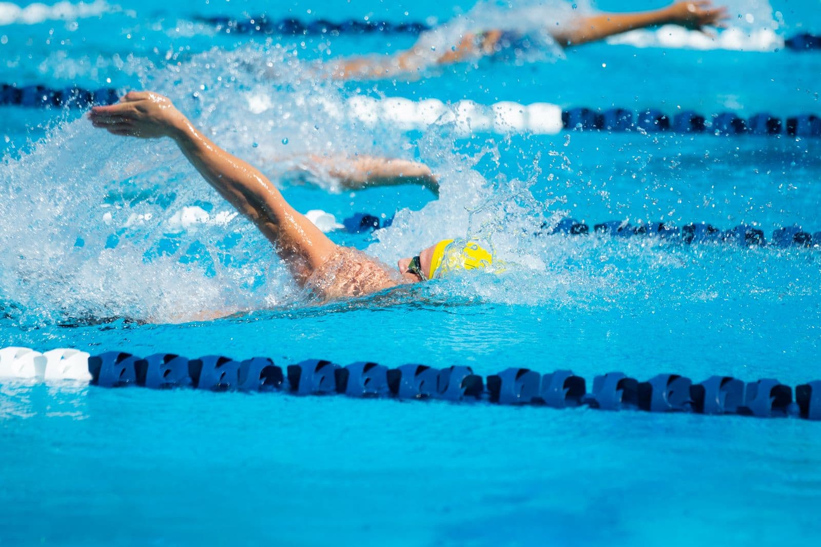 Competitive swimmers training in a bright outdoor pool