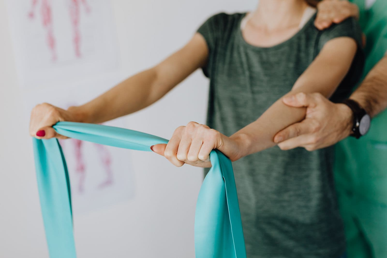 Clinician guiding a patient's shoulder exercise with a resistance band