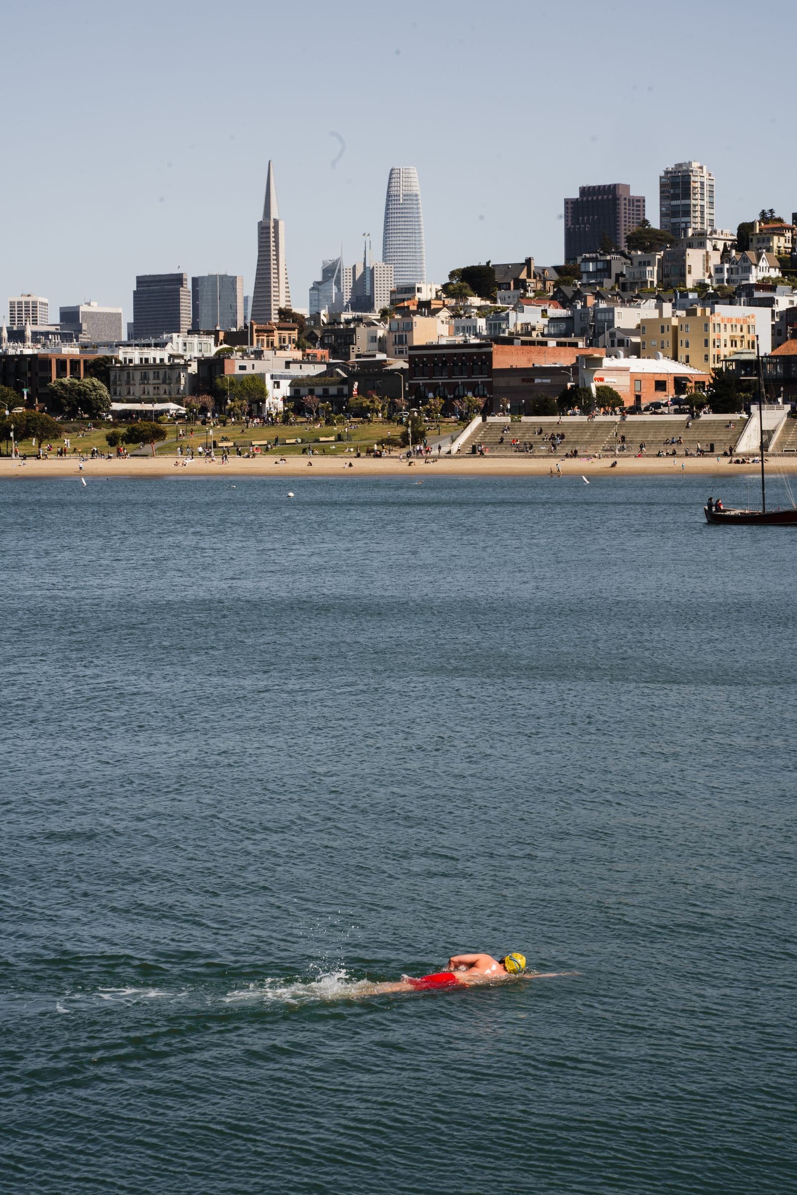 Open-water swimmer in San Francisco Bay with the city skyline behind