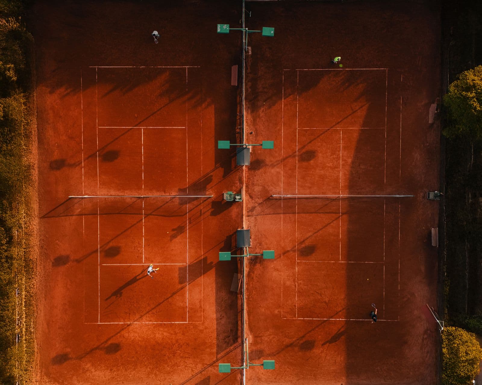 Aerial view of clay tennis courts at sunset