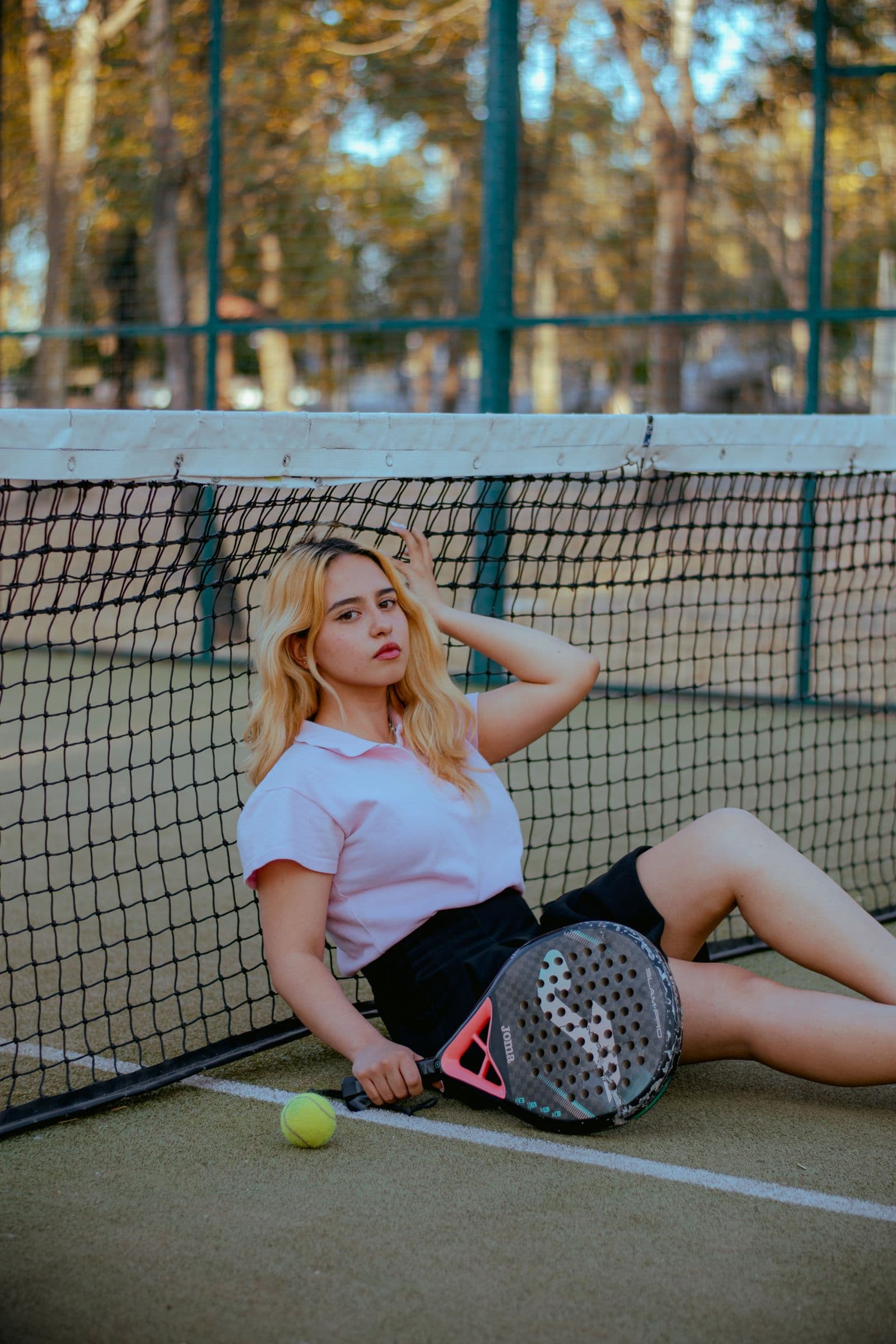 Tennis player resting on the court beside their gear