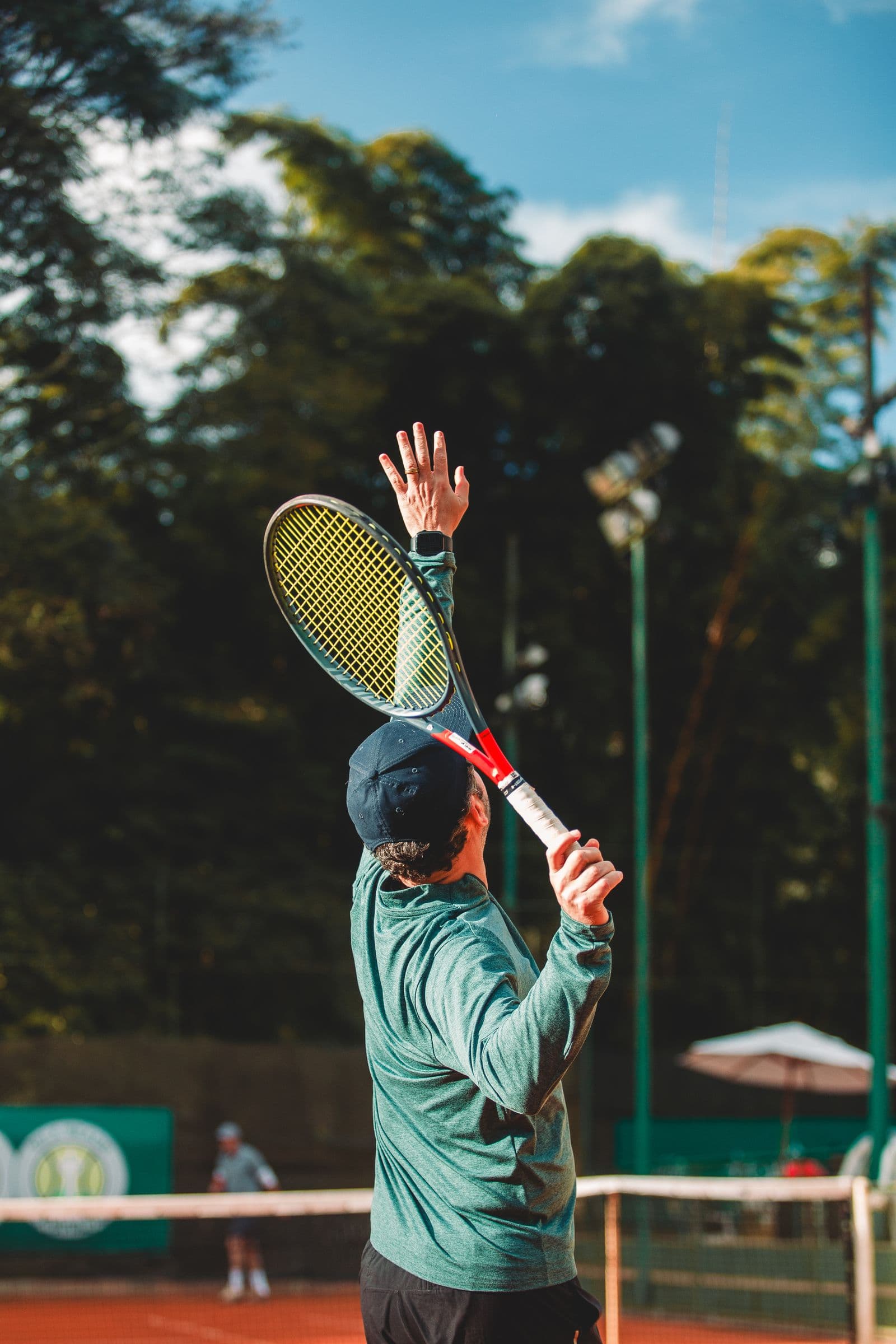Tennis player mid-serve on an outdoor hard court