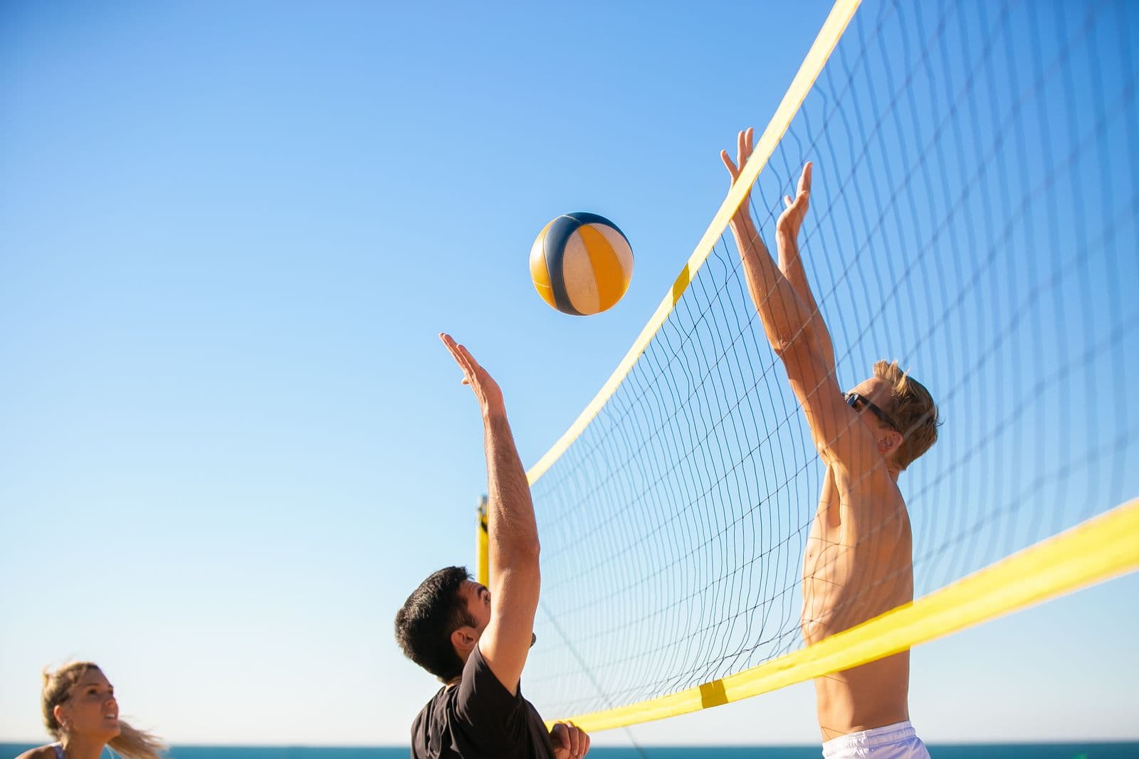 Player jumping to spike during a beach volleyball game