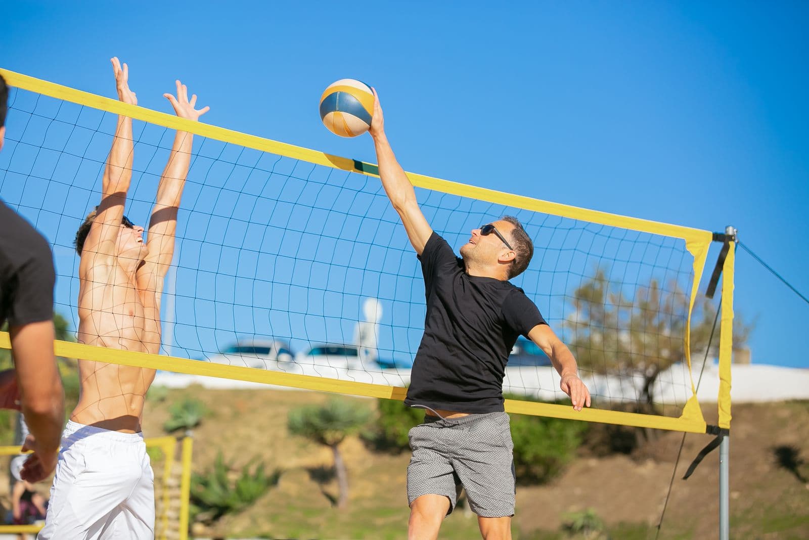 Two adult players competing in a beach volleyball game