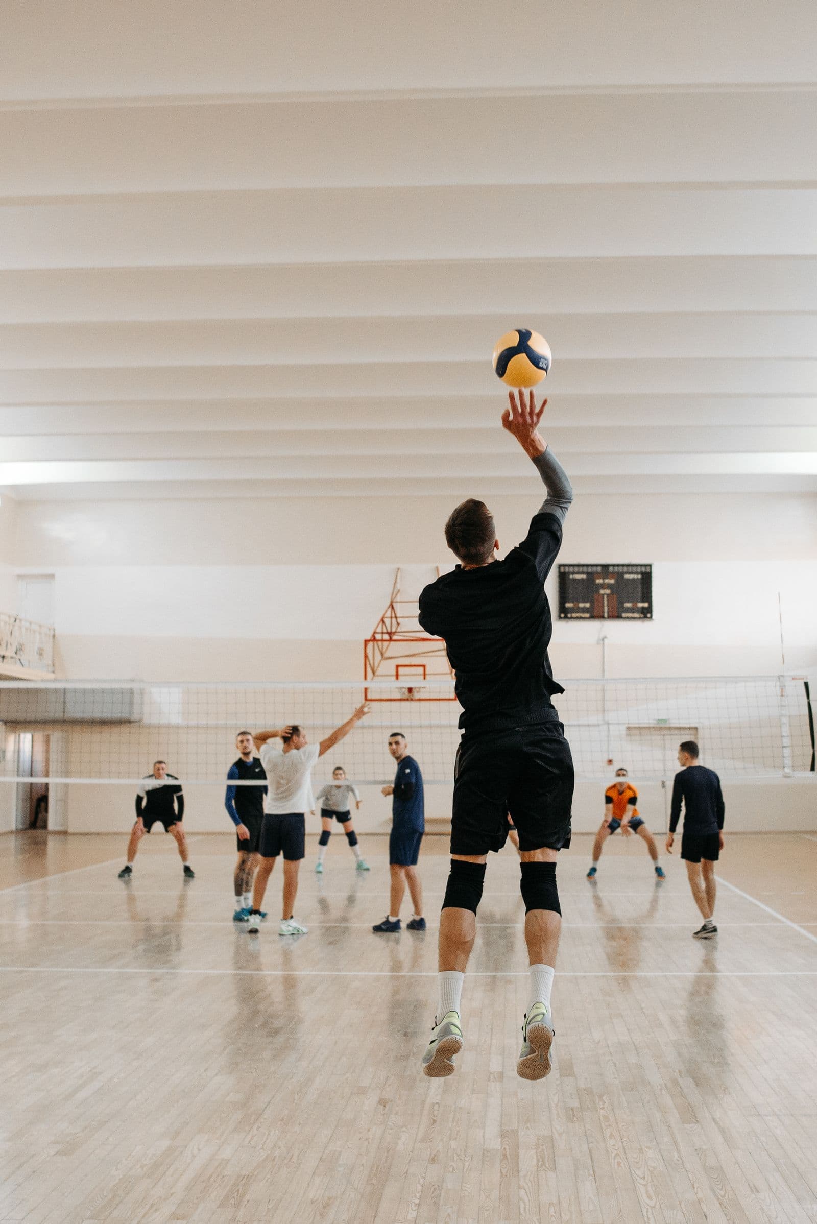 Player jumping to attack at the net in an indoor game