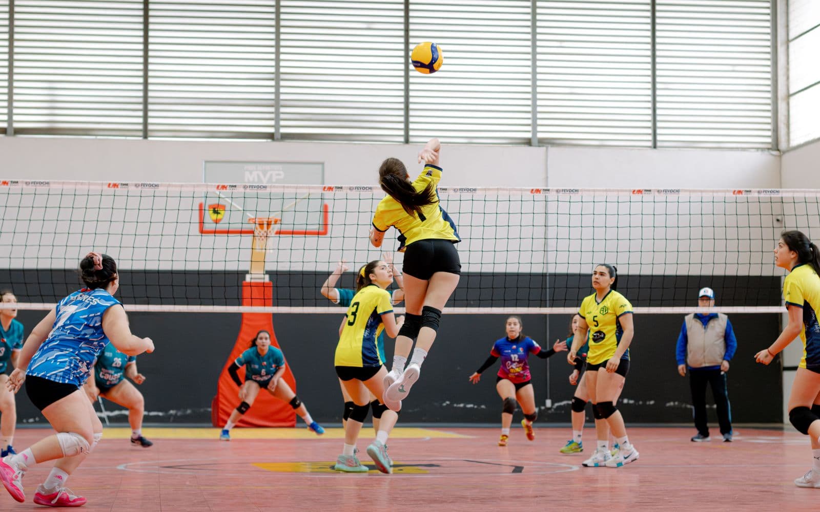 Player jumping for a spike during an indoor match