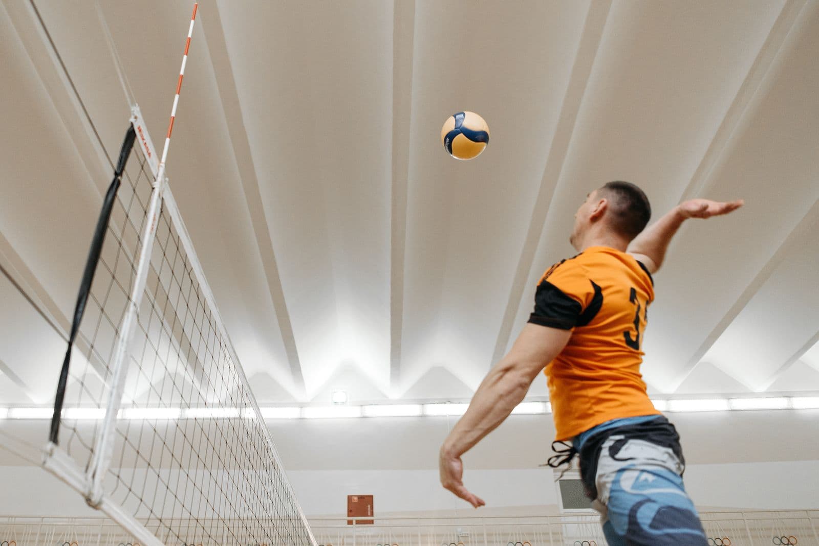 Hitter mid-spike at the net in an indoor match