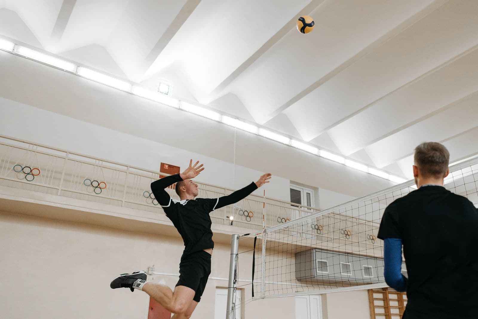 Two hitters mid-play in an indoor volleyball match